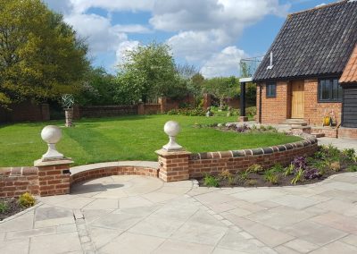 Curved wall with patio and step to lawn