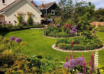 large front garden with circular flowerbeds and lawn